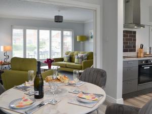 a dining room with a table with a bottle of wine at Poppys' Place in Sewerby +32 photos