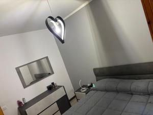 a bedroom with a bed with a heart light on the wall at Silvana Home in Marina di Sorso