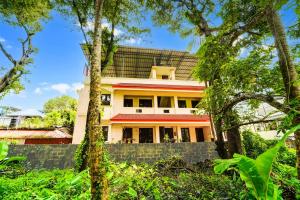 a house in the middle of a forest of trees at Hotel O Nettoor Near Lakeshore Hospital in Cochin