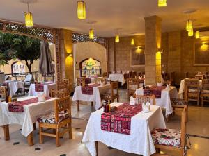 a restaurant with tables and chairs in a room at Jewel Howard Carter Hotel in Luxor
