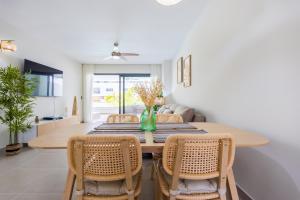プンタ・カナにあるBrand New 2BR Stylish Apartment in the Heart of Punta Cana, Gardenia Gated Communityのテーブルと椅子のあるダイニングルーム