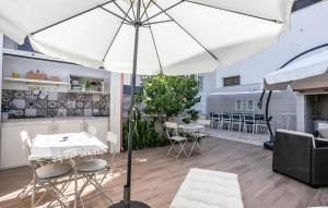 a large white umbrella in a room with a table and chairs at Lovely Home In Punta Braccetto in Punta Braccetto