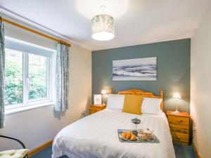 Un dormitorio con una cama con una bandeja de fruta encima. en Tides Reach - Uk47209, en Aberdyfi 9 fotos más