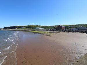 a sandy beach with a group of buildings in the background at Georgian Town House in Whitehaven