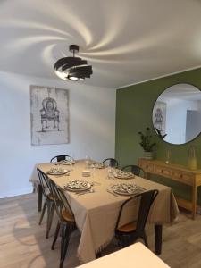a dining room with a table with chairs and a mirror at La belle échappée in Recloses