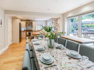 Un comedor con una mesa con un jarrón de flores. en Whydown Cottage, en Hooe