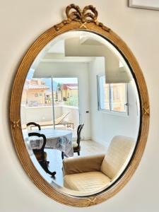 a mirror reflecting a living room with a couch and a table at Blu Mare Casa Vacanza in La Maddalena +37 photos