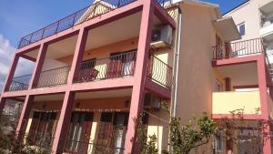 un edificio de apartamentos con balcones laterales en Apartmani Maric, en Tivat 3 fotos más