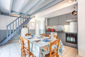 a dining room with a table and chairs and a kitchen at Maison avec Jardin proche Océan in Saint-Denis-dʼOléron +18 photos