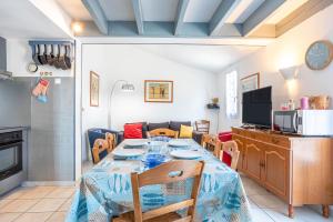 a kitchen and dining room with a table and chairs at Maison avec Jardin proche Océan in Saint-Denis-dʼOléron
