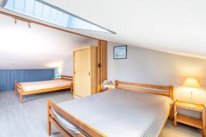 a bedroom with two beds and a window at Maison avec Jardin proche Océan in Saint-Denis-dʼOléron