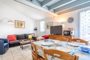 a living room with a table and a couch at Maison avec Jardin proche Océan in Saint-Denis-dʼOléron