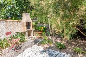 a backyard with a stone fireplace and a table and chairs at Maison avec Jardin proche Océan in Saint-Denis-dʼOléron