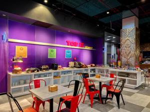 Việt TrìTru by Hilton Viet Tri City Centre的一间有桌椅和紫色墙壁的餐厅