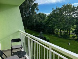 a balcony with two chairs and a green wall at Warmia Dream Apartament in Olsztyn