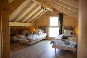 a bedroom with two beds in a wooden cabin at Le P'tit Chalet - Randonnée, ski et nature près d'Evian et du Léman in Saint-Paul-en-Chablais
