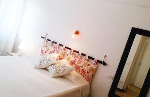 una camera da letto con un letto con cuscini sopra di La Casetta Al Mare a Santa Marinella