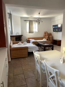 a living room with two beds and a table and chairs at Oikos Corfu in Alepou