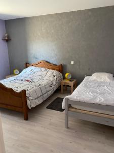a bedroom with two twin beds and two tables at Loue maison quartier calme in Royan