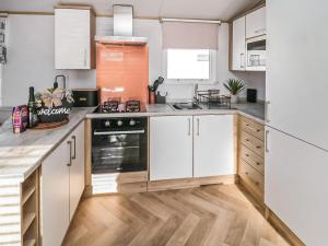 a kitchen with white cabinets and a stove at Long View Lodge in Felton +20 photos