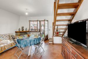 Un comedor con una mesa y un televisor. en La Casa Di Dadà - Happy Rentals, en Oulx