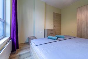 a bedroom with a large bed with blue pillows on it at My Space Deluxe One Bedroom Apartment in Sofia