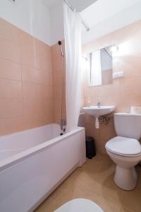 a bathroom with a tub and a toilet and a sink at Apartament Ku Słońcu - Hel in Hel