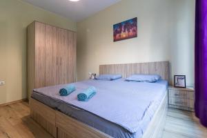a bedroom with a large bed with blue pillows on it at My Space Deluxe One Bedroom Apartment in Sofia +5 photos