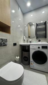 y baño con aseo, lavabo y lavadora. en Sunset Studio Apartment, en Batumi