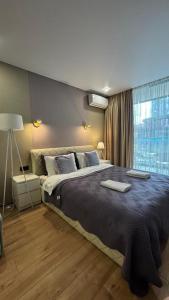 Un dormitorio con una cama grande y una ventana en Sunset Studio Apartment, en Batumi