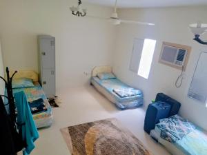 Zimmer mit 2 Betten und einem Teppich in der Unterkunft Cozy Vibes Hostel in Muscat
