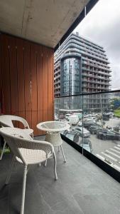 Un balcón con una mesa y sillas y un edificio. en Sunset Studio Apartment, en Batumi 16 fotos más
