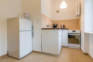 a kitchen with white appliances and a white refrigerator at Apartament Ku Słońcu - Hel in Hel