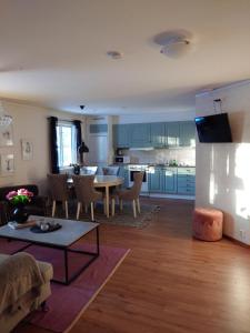 ein Wohnzimmer mit Tisch und Küche in der Unterkunft Jävregården in Jävre + 4 Fotos