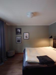 ein Schlafzimmer mit einem Bett und drei Bildern an der Wand in der Unterkunft Jävregården in Jävre