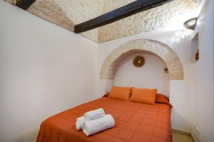 a room with a bed with two towels on it at Trullimania in Alberobello