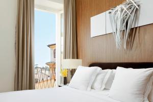 a bedroom with a bed with white pillows and a window at The First Dolce - Preferred Hotels & Resorts in Rome