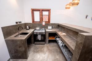a kitchen with a sink and a stove at Turtle Bay Cottage in Kosgoda +21 photos