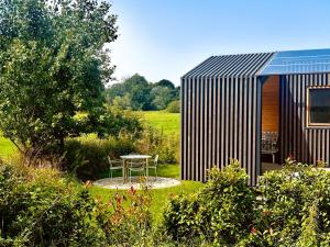 a small house with a table in a garden at 101 Tiny House Elbhütte mit Wiesenblick in Bleckede