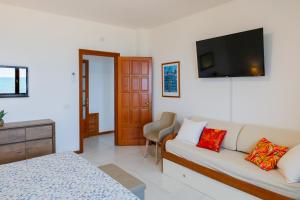 a living room with a couch and a flat screen tv at Villa Fausta in La Maddalena