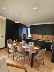 a dining room with a wooden table and chairs at 3BiS Apartment in Fushë-Krujë +7 photos