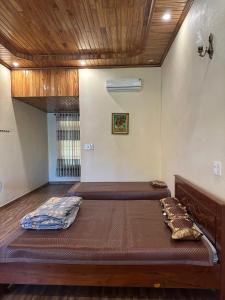 a bedroom with two beds and a wooden ceiling at Temple Stay - Diem Phung Pagoda 