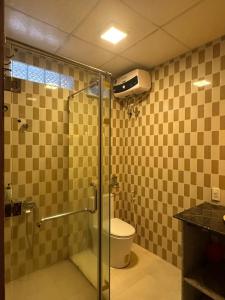 a bathroom with a shower and a toilet with a glass door at Temple Stay - Diem Phung Pagoda 
