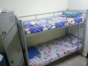 2 Etagenbetten in einem kleinen Zimmer mit einem Bett in der Unterkunft Cozy Vibes Hostel in Muscat + 35 Fotos