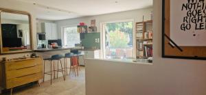 une cuisine avec un bar avec tabourets et une fenêtre dans l'établissement La Maison du Soleil, à Saint-Didier