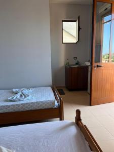 a bedroom with a bed and a bathroom with a sink at Begaj Rooms in Durrës