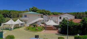 a large house with white tents in a yard at Albergo Athena Mare in Sibari