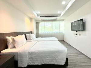 a bedroom with two beds and a flat screen tv at Civic Park in Bangkok +36 photos
