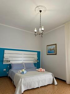 a bedroom with a large bed with a chandelier at Casa Euphorbia in Portoscuso