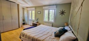 une chambre avec un lit et deux fenêtres dans l'établissement La Maison du Soleil, à Saint-Didier 18 autres photos